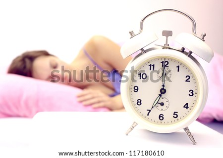Beautiful woman sleeping soundly and the alarm clock awakens in time,Women and alarm clock,photography