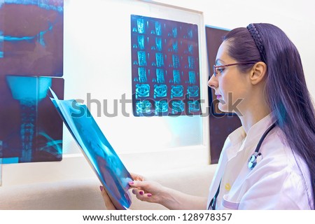 Young female doctor standing at the table with X-ray, X-rays, photography
