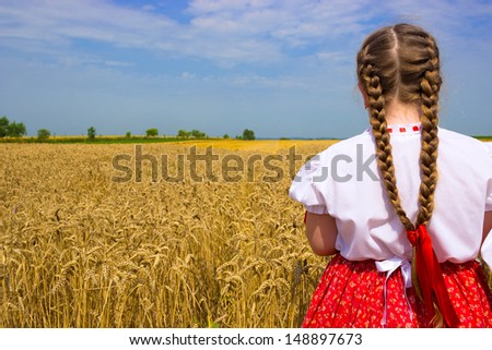 Girl in national dress standing and looking at the wheat field, Field of wheat, photography