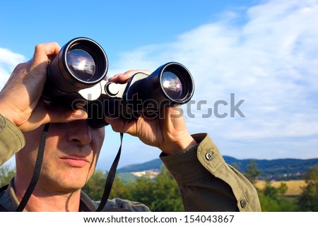 Young man with binoculars watching birds in nature, Man with binoculars, photography