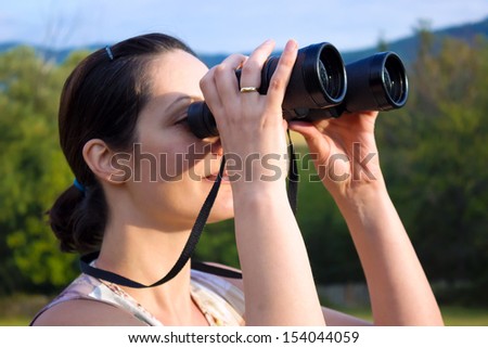 Young woman with binoculars watching birds in nature, Woman with binoculars, photography