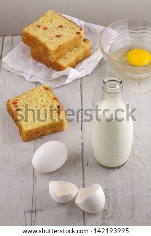 milk egg and sweet bread on white wood, ingredients for baking