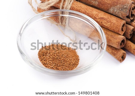 Cinnamon sticks with cinnamon powder in glass bowl