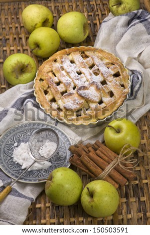 Homemade apple pie with green fresh apples and cinnamon sticks