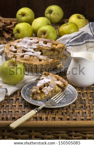 Slice of traditional american apple pie with fresh cream and green apples