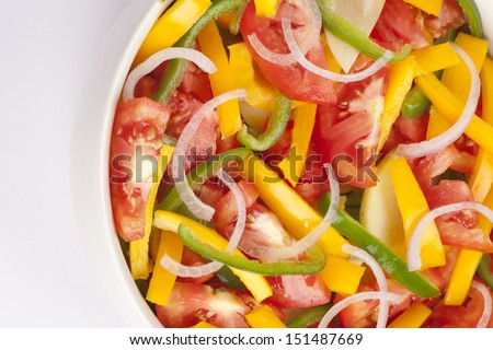 Salad bowl with onion, yellow and green bell pepper, tomato