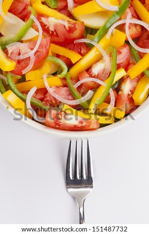 Salad bowl with onion, yellow and green bell pepper, tomato