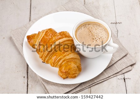 breakfast with croissants, cup of coffee and milk