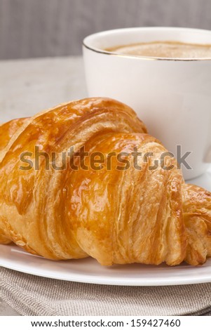 breakfast with croissants, cup of coffee and milk