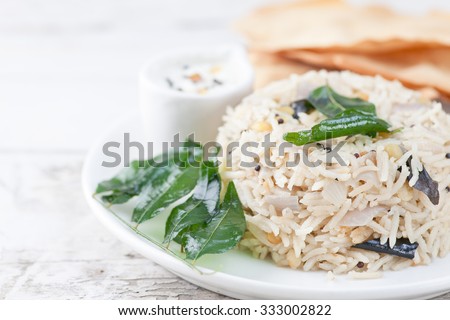 Coconut rice with chutney, curry leaves and papadum. South indian food.