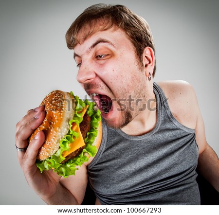 fat man eating hamburger seated on armchair