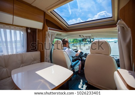Man driving on a road in the Camper Van RV. Caravan car Vacation. Family vacation travel, holiday trip in motorhome