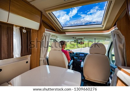 Man driving on a road in the Camper Van RV. Caravan car Vacation. Family vacation travel, holiday trip in motorhome