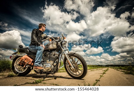 Biker in sunglasses and leather jacket on the road