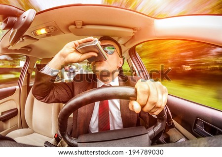 Drunk man in a suit and sunglasses driving on a road in the car vehicle.