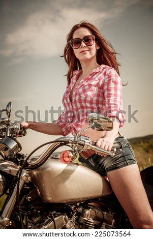 Biker girl with sunglasses sitting on motorcycle