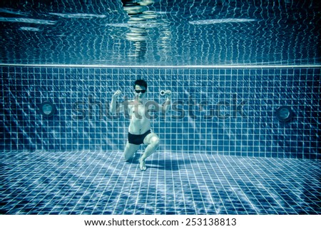 Man posing as Superman underwater swimming pool