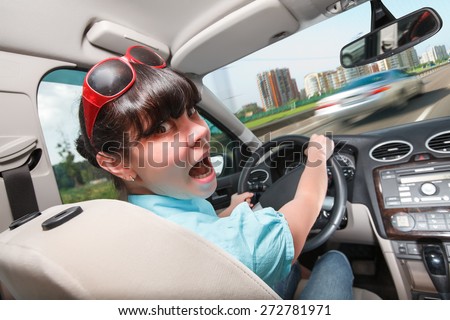 Woman in panic behind the wheel of the car. Driving lessons The woman behind the wheel..