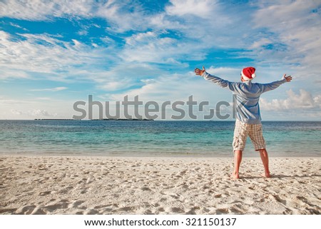 Christmas vacation - man in santa hat on the tropical beach
