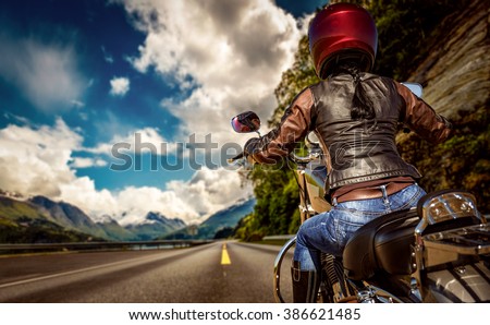 Biker girl rides a motorcycle in the rain. First-person view.