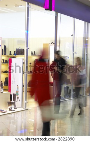People in shopping center near a show-window of shop...