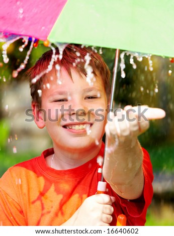 boy under an umbrella during a rain ...