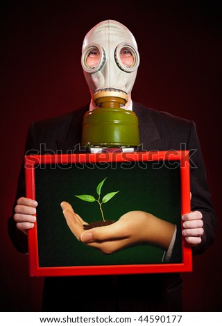 person in a gas mask with a picture in a hand