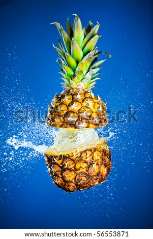 Pineapple splashed with water on a blue background