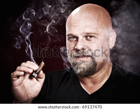 bald man with a beard smokes a cigar