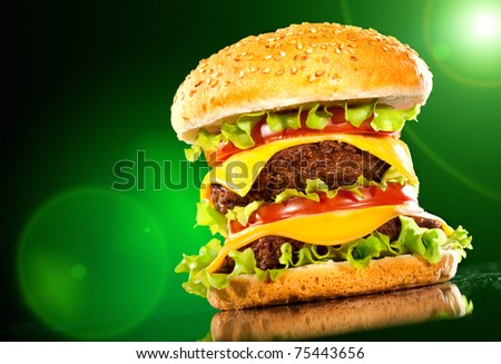 Tasty hamburger and french fries on a dark background