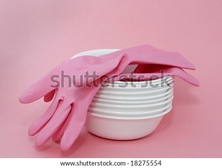 pink gloves on pile of stacked white bowl.