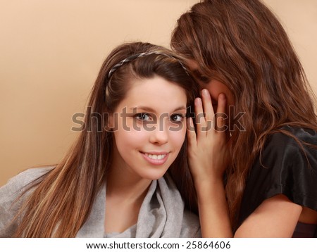 girl whispering in ear on her best friend