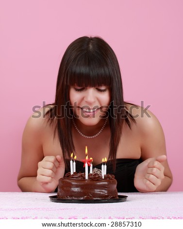cute girl looking at her chocolate birthday cake