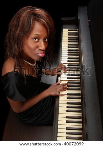 portrait of beautiful black woman sitting at piano