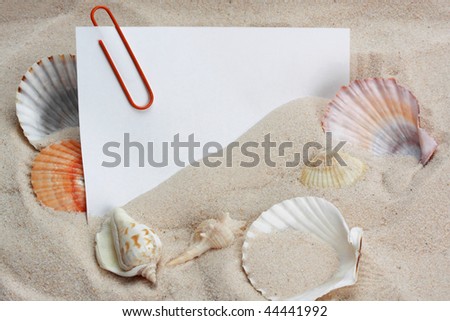 message paper with paper clip on beach sand