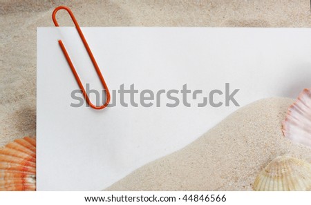 message paper with paper clip on beach sand