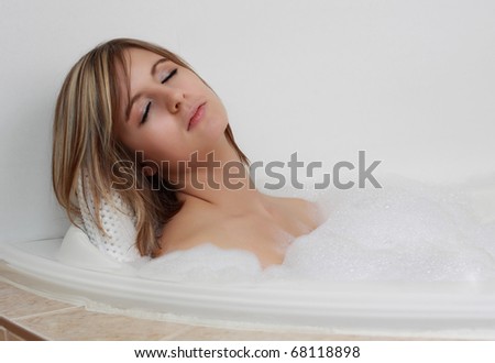 young caucasian woman relaxing in her bath with foam bubble