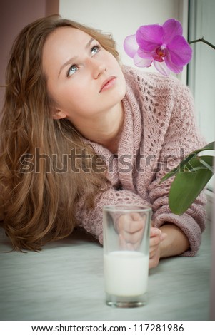 Young beautiful woman with a glass of fresh milk.