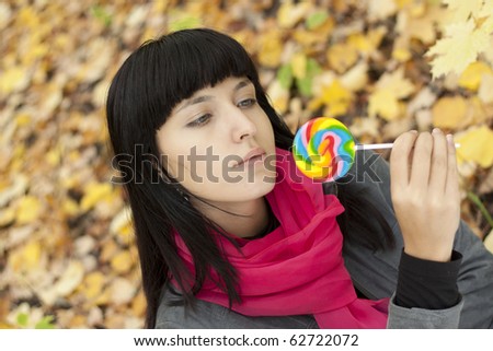 Young beautiful woman eating candy.