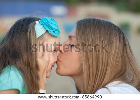 Mother kissing her little child. Happy young mother and daughter