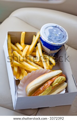 Fast-food Lunch - Image of a fast-food box lunch with a hotdog, fries and cola on the car seat.