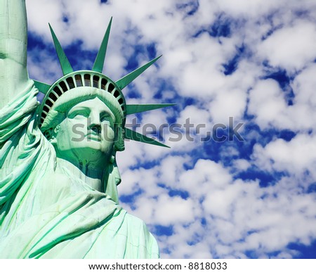 Close-Up of Statue of Liberty against a cloudy blue sky.