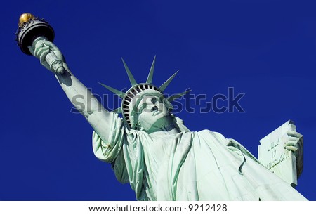 Close-up of Statue of Liberty against a bright blue sky.