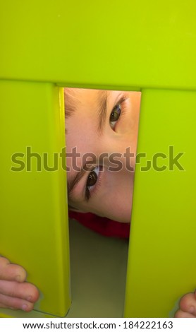 Little boy looking behind a chair