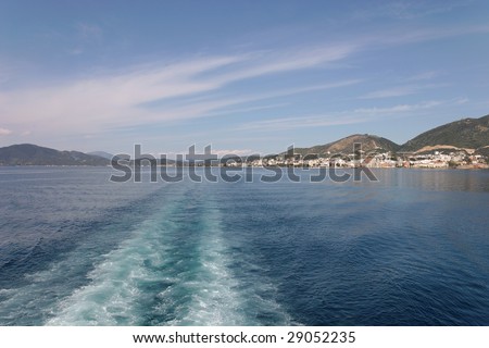 Wake (propeller wash) from a cruise ship with Greek island in the horizon
