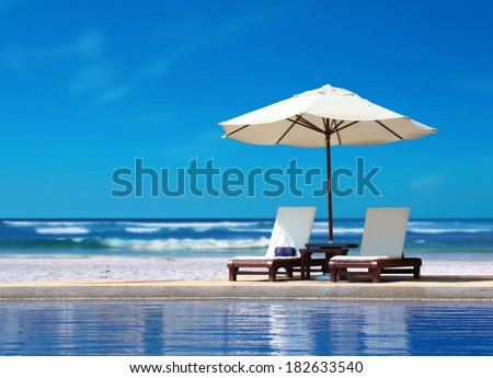 Two Chairs with White Umbrella near the Beach