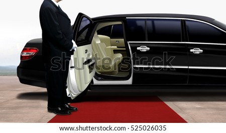 Driver waiting and standing next to the black limousine on a red carpet