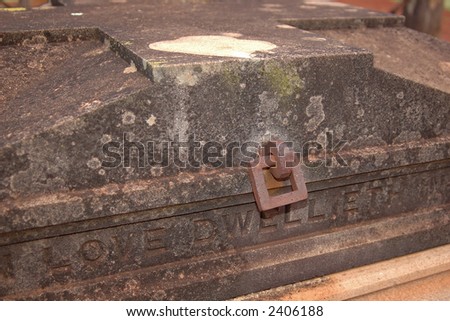 An old tomb with a cross top, and iron fittings. Very vampiric. Inscription \