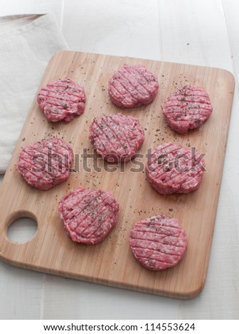 Beef patties round on cutting board top view vertical