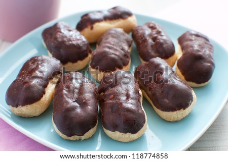 Plate with eclairs with chocolate coating and custard